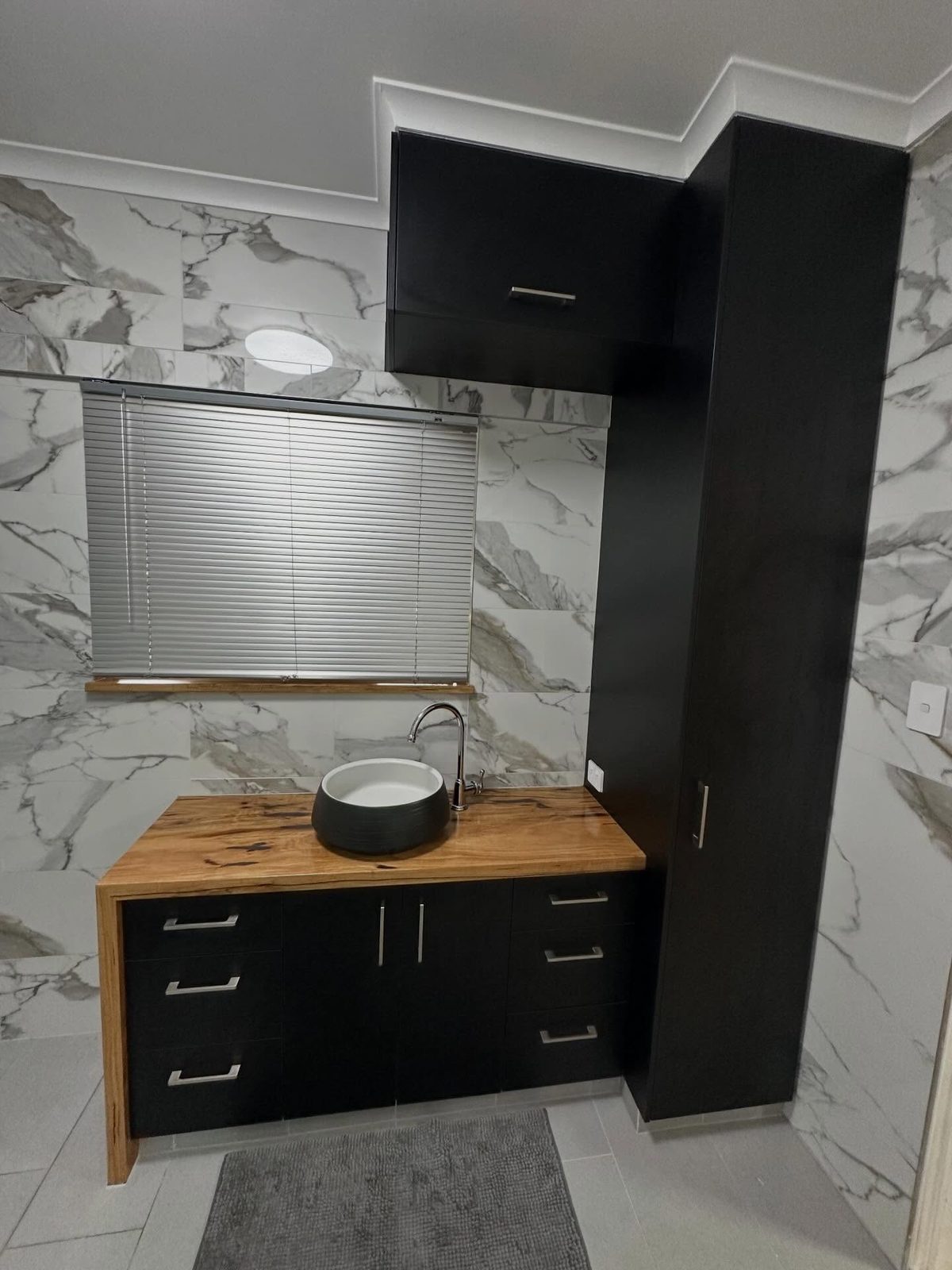 After: the vanity and the tall black hutch built above the bathroom window