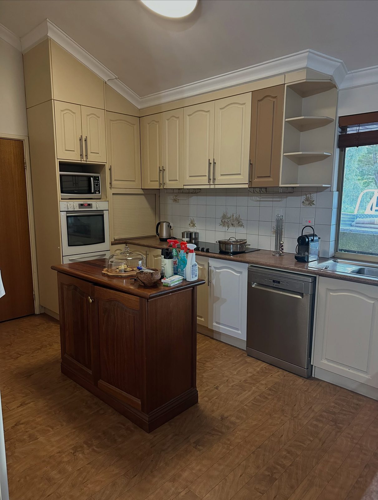 Before: cream cabinets, a dark timber island and cork floor
