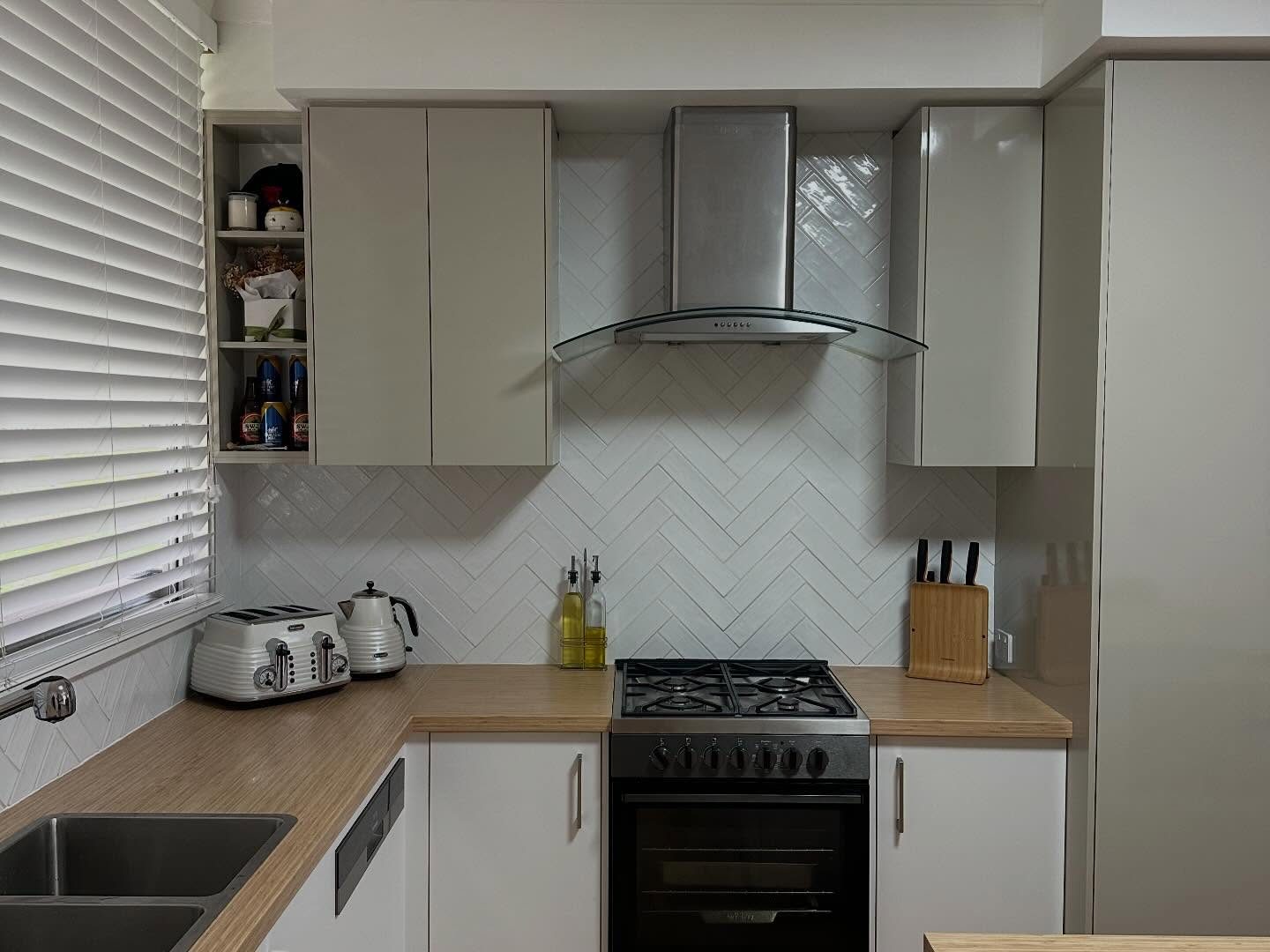 After: island bench with stools and tall cabinetry around the fridge