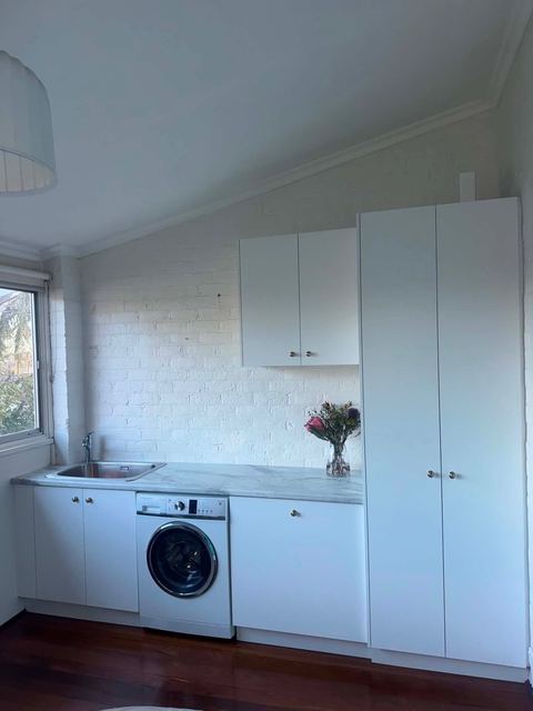 Laundry with tall storage cupboards beside the washing machine